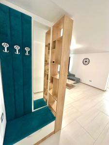 a room with a green wall and a book shelf at B2 Boutique Apartments in Năvodari