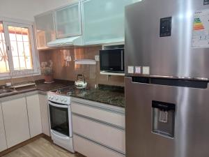 a kitchen with a stainless steel refrigerator and cabinets at Gabino House II in Luján