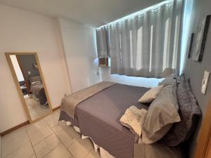 a bedroom with a large bed and a mirror at Lapa reformado melhor localização in Rio de Janeiro