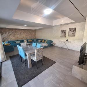 a living room with a table and a blue couch at Casa Serenity Villa Taghazout Bay Tamda in Taghazout