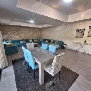 a dining room with a table and blue chairs at Casa Serenity Villa Taghazout Bay Tamda in Taghazout