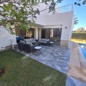 a living room with a couch and a table at Casa Serenity Villa Taghazout Bay Tamda in Taghazout