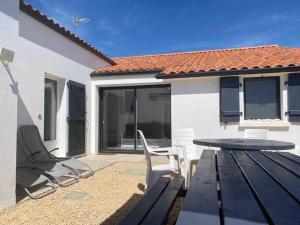 a patio with a table and chairs in front of a house at Le Jaunay holiday in Saint-Gilles-Croix-de-Vie