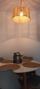 a dining room table with two chairs and a chandelier at Apartamento Neron in Ronda