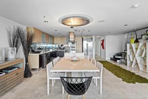 - une cuisine avec une table à manger blanche et des chaises dans l'établissement Beachfront - Panoramic View 4BR Penthouse - PH4, à Palm-Eagle Beach
