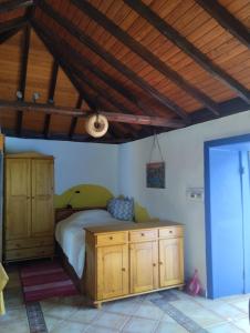 a bedroom with a bed and a wooden cabinet at Casa Mosaico, sunset and garden in Los Llanos de Aridane