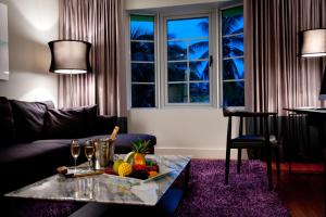 a living room with a table with a bowl of fruit at Leslie Hotel Ocean Drive in Miami Beach