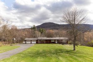 a barn with a tree in front of a field at Charming home - views of Hunter Mountain slopes in Hunter