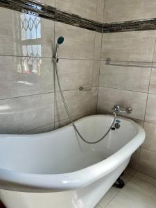 a white bath tub in a bathroom with a shower at The Ripanga Nest in Nelspruit