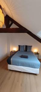 una camera da letto con un letto con lenzuola e cuscini blu di La Suite Mìmì 光 Duplex - 2chambres2Sallesd'eau - Second Lodge Rennes a Rennes Altre 16 foto