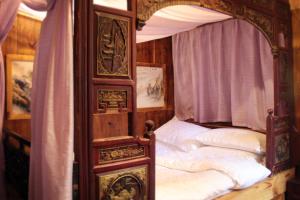 1 dormitorio con cama con dosel y almohadas blancas en Xishan Wutong Qinyuan (Free Pick up Service), en Huangshan