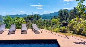 a group of chairs sitting on a patio next to a pool at Villa de Montchamp in Chambonas