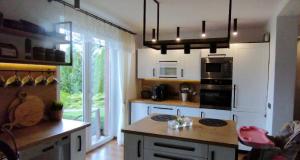 a kitchen with white cabinets and a stove top oven at Agroturystyka u Lusi in Rytel