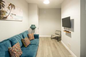 a living room with a blue couch and a flat screen tv at The Cozy Two beds, FREE parking, SKY in Bedford