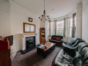 a living room with a couch and a fireplace at Athol House in Douglas