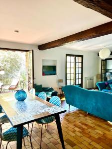salon z niebieską kanapą i stołem w obiekcie Entre Nice et Monaco grande Villa avec piscine privée 12 personnes w mieście Drap