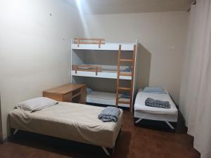 a small room with two beds and a bunk bed at Pousada Jardim Botanico SEM estacionamento in Curitiba