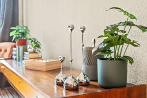 a table with four vases and a potted plant on it at 3 Zimmer, Beamer, Balkon, Disney Plus in Woltersdorf