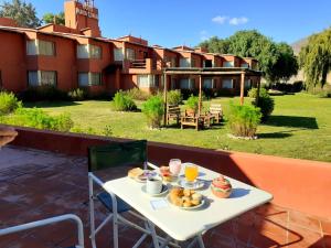 a table with food and drinks on a patio at Hotel Punta Corral in Tilcara