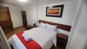 una camera con un letto con una coperta rossa e bianca di INCA PALACE EXPERIENCE Hotel a Puno