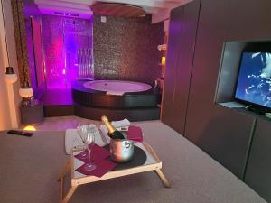a bathroom with a tub and a table with a bottle of champagne at Luxury Room & Private Spa - Rio Botteniga in Treviso