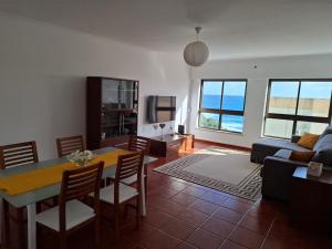 una sala de estar con una mesa y un sofá en Populo Beach Apartment, en São Roque