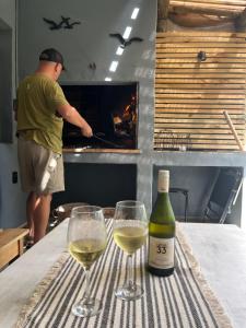 two glasses of white wine sitting on a table with a bottle at Puerta Azul in Punta del Este