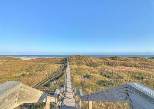 a wooden boardwalk leading to the ocean on a beach at Casa Playa - Ocean Views Pet Friendly Boardwalk in Port Aransas