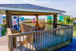 a wooden deck with a gazebo with flags on it at Casa Playa - Ocean Views Pet Friendly Boardwalk in Port Aransas +40 photos