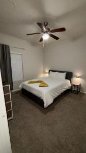 a bedroom with a bed with a ceiling fan at Hill Country Fairway Haven in Bee Cave
