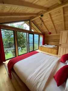 a bedroom with a large bed in a wooden house at Parla dağ evi kırmızı oda in Çamlıhemşin