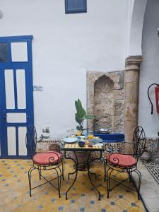 a table and chairs in a room with a blue door at Riad Safi - maison historique in Safi +47 photos