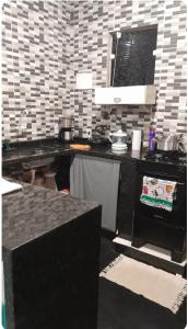 Una cocina con estufa y una encimera con ollas y sartenes. en Quintal Compartilhado - Casa Temporada, en Armacao dos Buzios 1 foto más