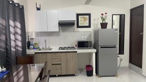 a small kitchen with a refrigerator and a sink at Departamento NEEM a 5 min del malecón in La Paz