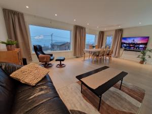 a living room with a couch and a table at apartment With fantastic view and parking in Tromsø