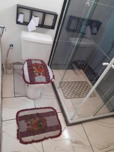 baño con aseo y ordenador portátil en el suelo en Quintal Compartilhado - Casa Temporada, en Armacao dos Buzios