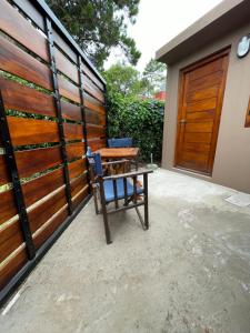 a wooden fence with a bench in front of a house at La comarca 1 in Villa Gesell