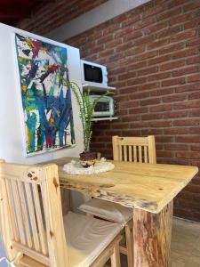 a wooden table with two chairs and a painting at La comarca 1 in Villa Gesell