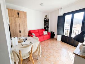 a living room with a red couch and a table at 01 - Vélez tropical in Vélez de Benaudalla