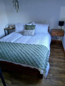 a bed with a blue comforter and pillows on it at Raithby Lakehouse in Raithby