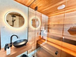 a bathroom with a sink and a mirror at Hossaville Luxe Lake Cabin in Hossa