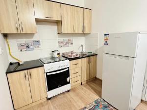 eine Küche mit einem weißen Kühlschrank und einem Herd in der Unterkunft Turkistan 1 in Türkistan