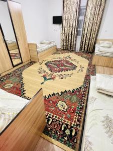 ein Zimmer mit zwei Betten und einem Teppich in der Unterkunft Turkistan 1 in Türkistan + 7 Fotos