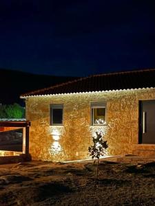 a building with lights on the side of it at night at Casa na Serra da Estrela - Solar do Prazo in Gonçalo