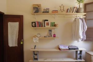 a room with bookshelves and a shelf on the wall at Quarto Casal com Varanda Casa Caramel in Belo Horizonte