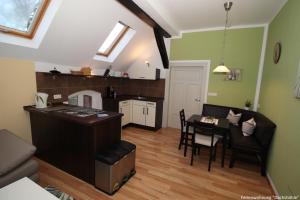 a living room with a table and a kitchen at Gutshof Kämmerich - Fewo Dachshöhle in Altkalen
