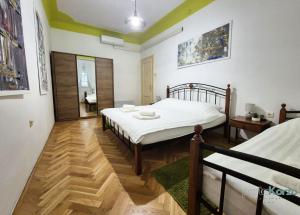 リエカにあるPortaKorzo Center Apartmentのベッド2台と木製の床のある寝室