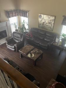 a living room with a leather couch and a coffee table at Room in a house in Lawrenceville in Lawrenceville +5 photos