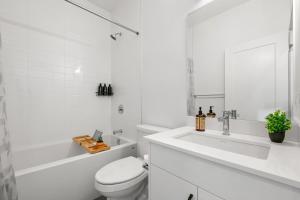 un bagno bianco con un water e un lavandino di Spacious 3 Story Townhome, 2 Car Garage, Sleeps 8, AC, King Bed, 10km from Calgary Downtown, Near Banff a Calgary