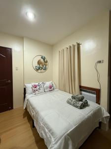 a bedroom with a bed with white sheets and pillows at A Suburban Haven, top floor unit with Balcony- at Camarin Caloocan City!! in Camarin